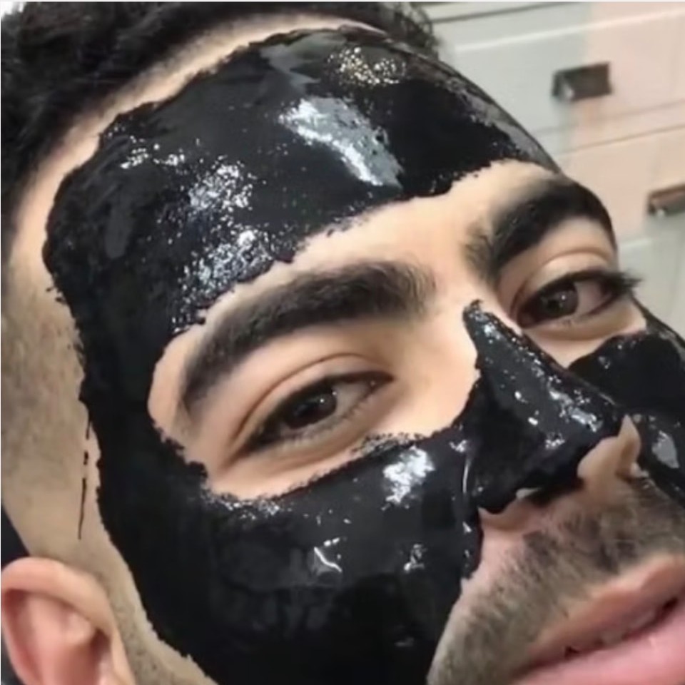 Client wearing a black charcoal pore cleansing mask