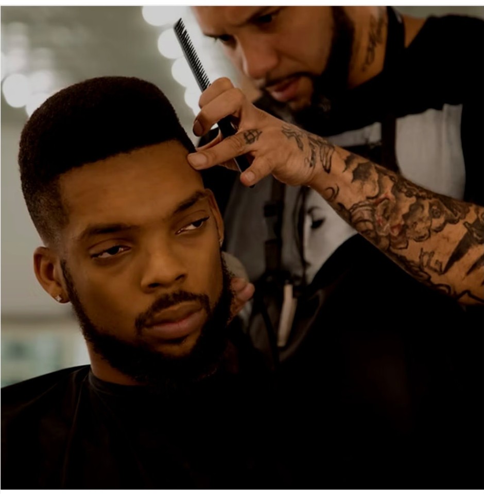 Kev combing and clipper-cutting an adult client's high-top fade at his Austin barber chair