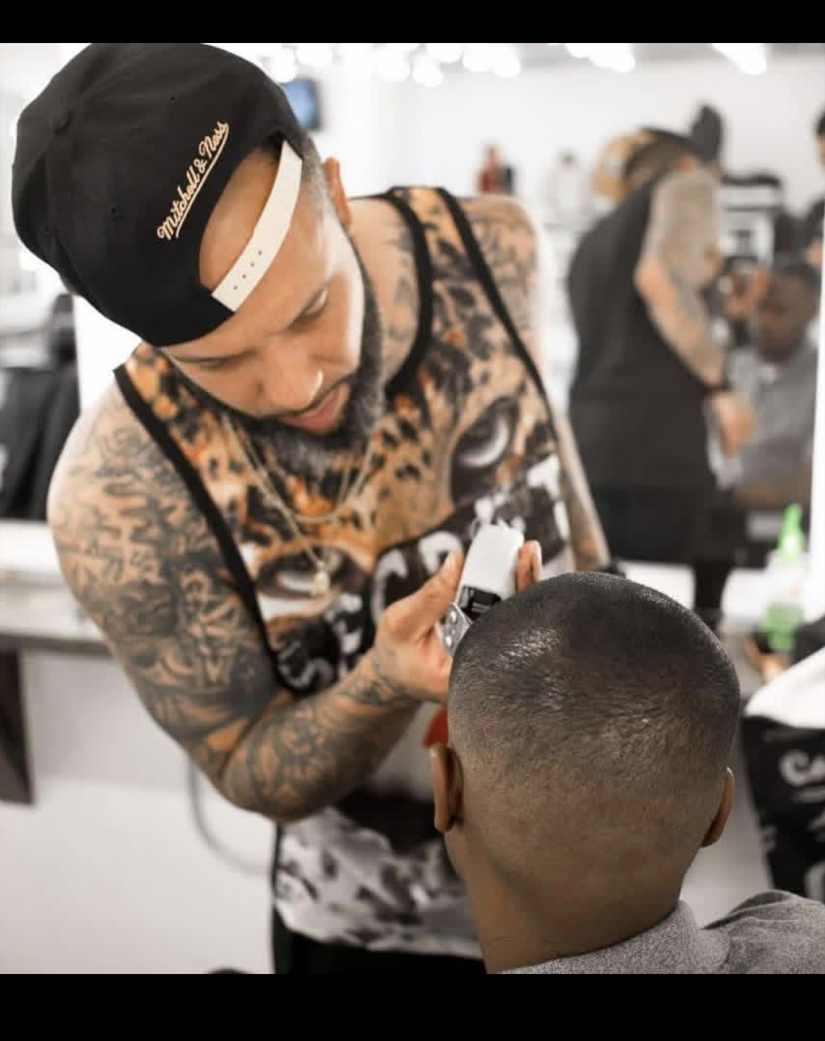 Kev the Barber lining up a client's fade with clippers inside the shop